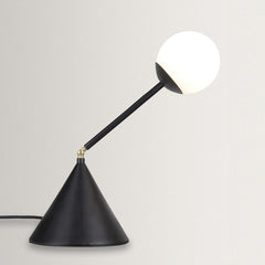 Black adjustable desk lamp with white bulb on a light gray background