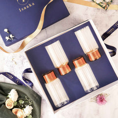 A set of four highball glasses with a striped design, displayed in a gift box with a blue background.