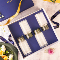 A set of four highball glasses with a striped design and grey base, displayed in a gift box with a blue background.