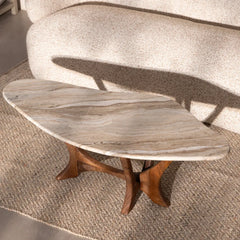 Marble-top coffee table with wooden base on a textured rug