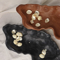 Two Kai Organic Bowls with pearls on a textured surface