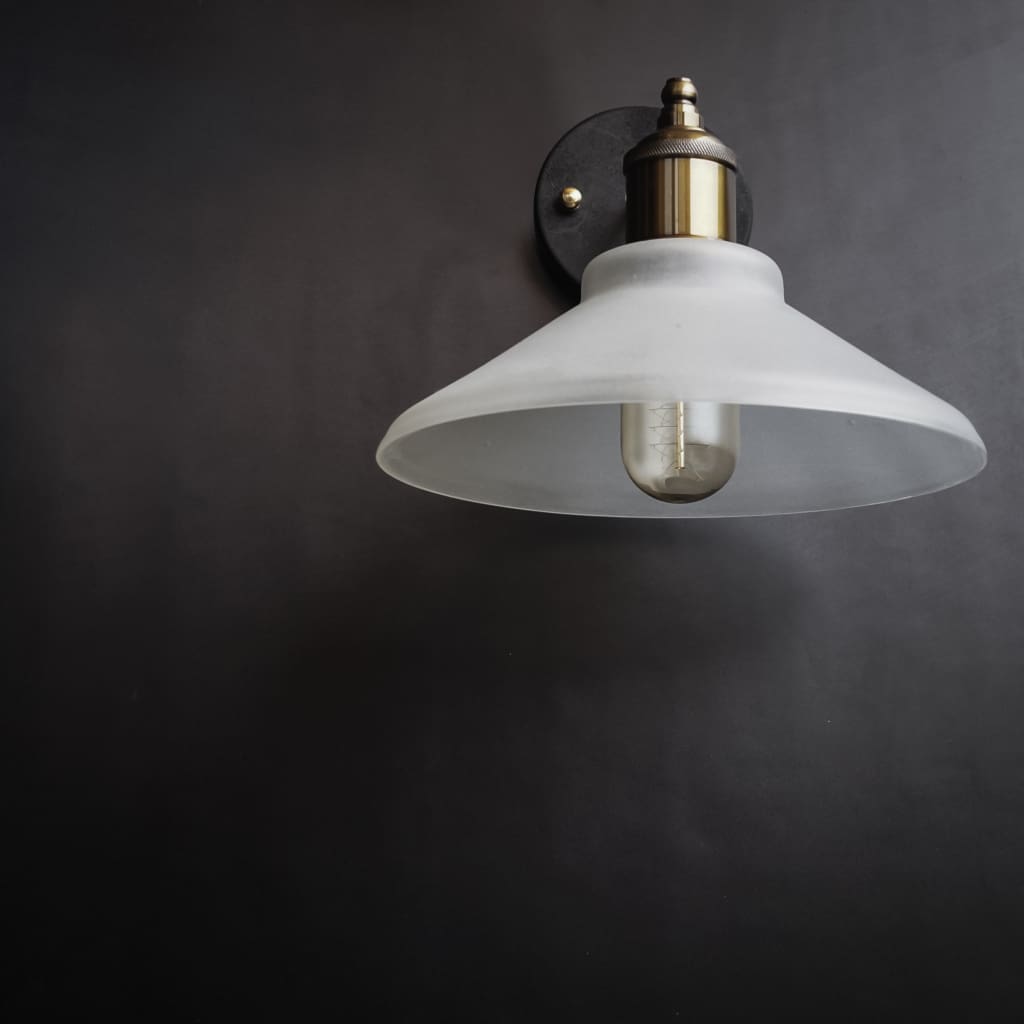 Nordic conical glass wall sconce frosted shade with golden interior on grey wall