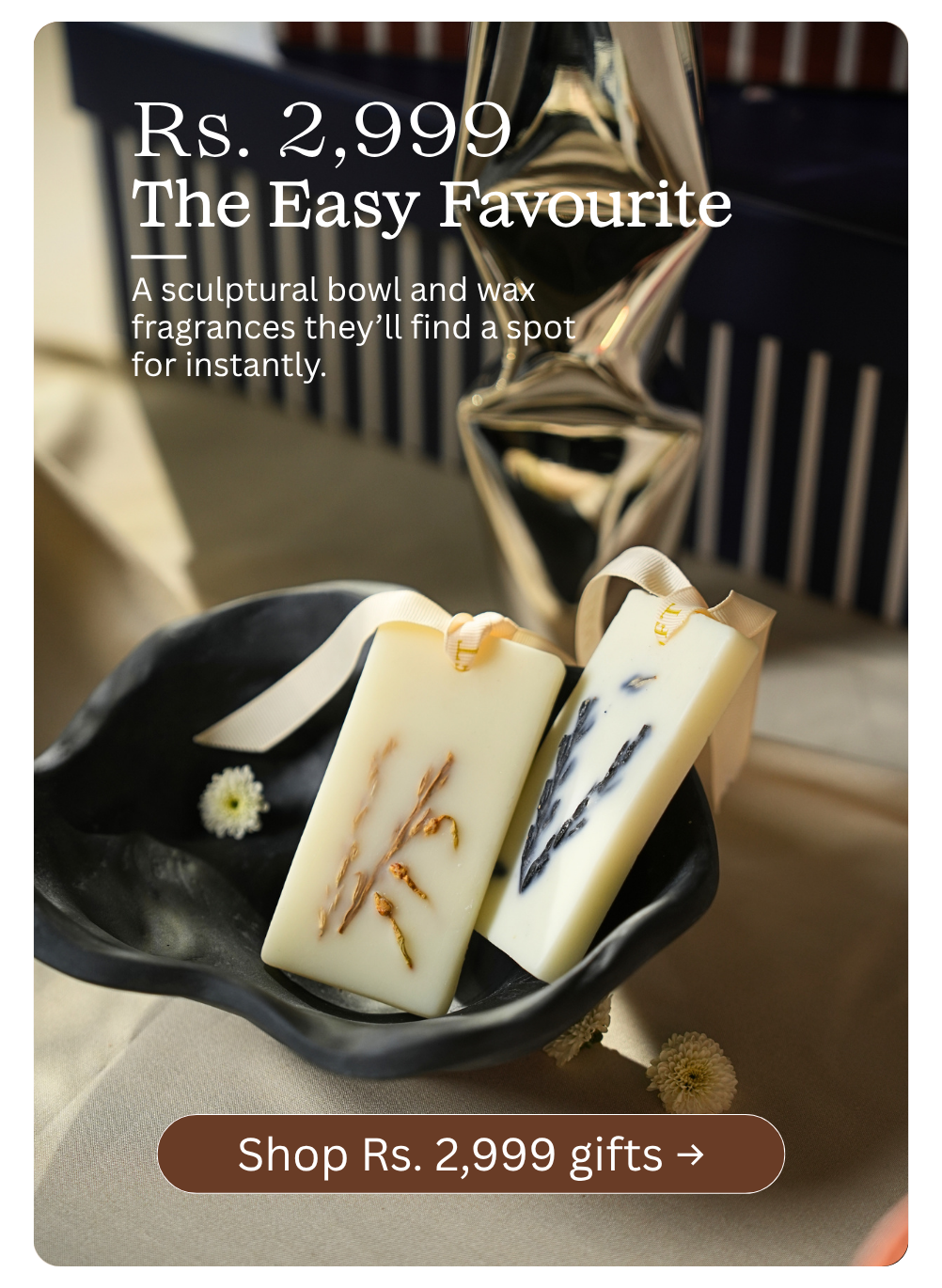 Promotional product image showing two rectangular wax bars in a black dish, with text reading  shop gifts under Rs. 2,999 