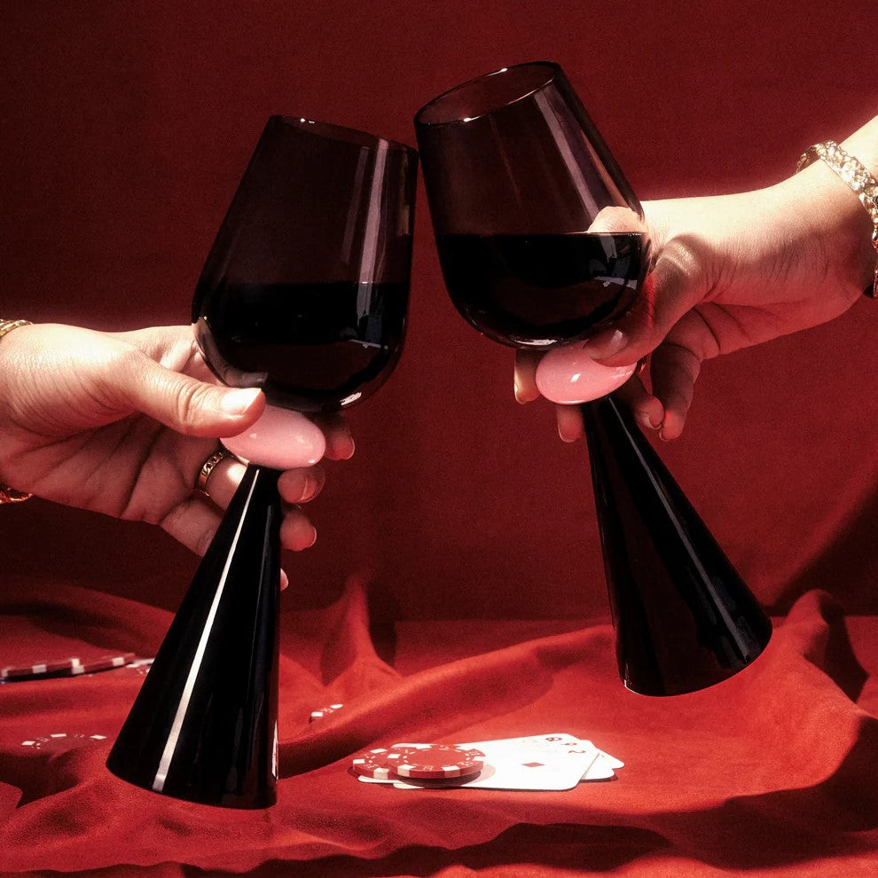 Two hands holding black twilight wine glasses