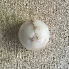 Lunar Wall Light featuring white marble-like sphere on a textured beige surface