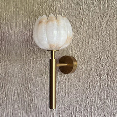 Unique Lotus Alabaster Wall Sconce with a textured white glass flower-shaped shade and a brushed brass gold-finished metal stem and wall mount.