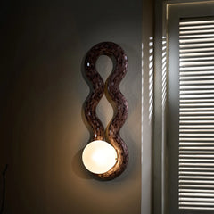 Reva Double Loop Wall Lamp Handcrafted in glass mosaic with wavy design on a dark wall.