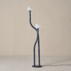 Modern floor lamp with two spherical lights on a plain background