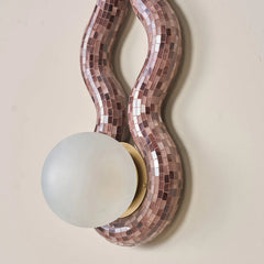 Close view of decorative wall light fixture with mosaic design and glass bulb