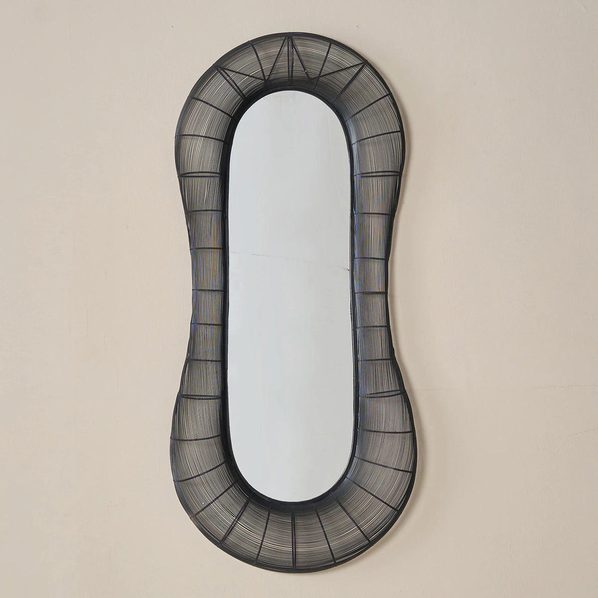 Decorative wall Midnight Black Mirror
with black wireframe frame on a beige wall