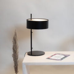 Svelte Scandi Table Lamp with a black shade and base, placed on a white base.