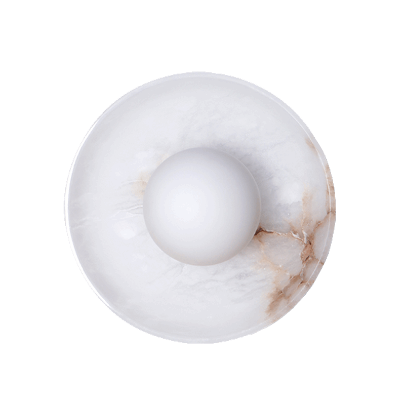 A Blot Wall Sconce with a round shade, featuring a mottled white stone material with hints of brown.