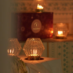 Decorative diamond shaped Kandeel votive in glass holders on a table with a blurred background
