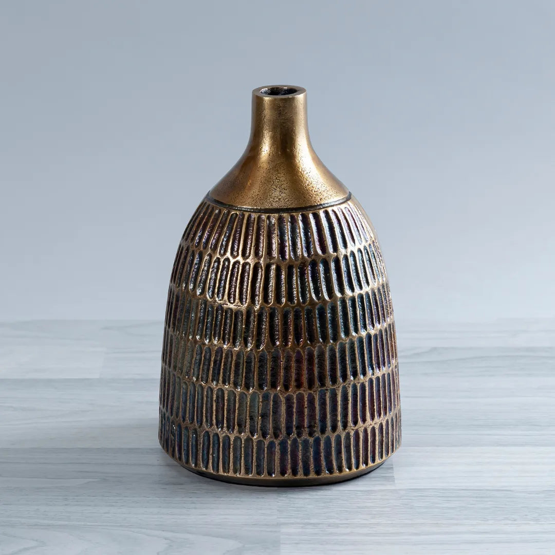 A decorative ceramic Vasiliki Vase with a textured, ribbed body and a flared metallic gold neck, set against a light gray background.