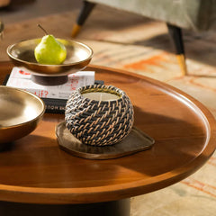 A woven black and beige decorative candle holder with a white candle, set on Belem Aluminium Tray.
