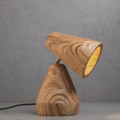 Video of unique stretch table lamp with a short, curved, brown marine plywood shade and brass base, featuring unique wood grain patterns.
