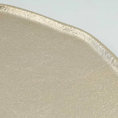 Close-up of a textured Belem Aluminium tray in a warm beige tone, showing the rough, matte finish and a slightly raised rim against a light gray background.