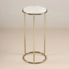 Small round table with marble top and gold metal frame on a beige background