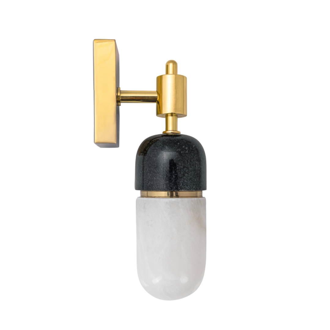 A capsule wall light fixture with a black marble and alabaster stone capsule, polished brass gold metal finish and a G4 LED bulb.