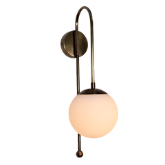 A wall sconce glass globe with raw brass finish