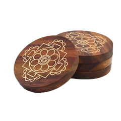 A set of four round Sheesham wood Mandala Coasters with a cosmic mandala pattern engraved on them.