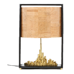 City of Light table lamp with a brass cityscape base and a cork sheet shade, mounted on a dark matte wood finish stand.