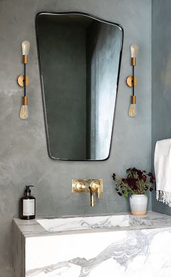 Modern Parisienne 2 Bulb Wall Lamp mounted next to the mirror, filament bulbs casting warm ambient light upward and downward.