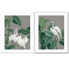 Two framed wall art prints of paper cranes surrounded by foliage.