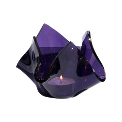 Purple glass candle holder with a lit candle on a white background