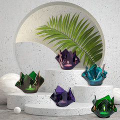 Decorative crumpled candle holders on a concrete surface with a leaf decoration in the background.