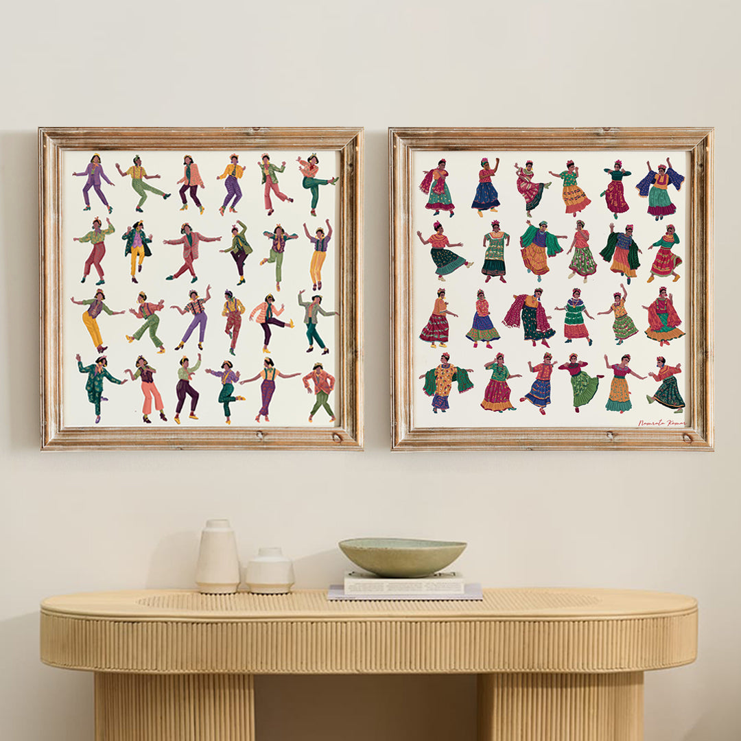 A set of two framed art prints featuring an acrylic painting with various colorful characters dancing, displayed on a wooden table with a white bowl a