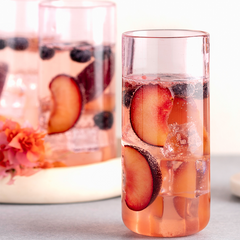 Close view of Juliette Cocktail Glass in pink with drink filled with fresh fruits.