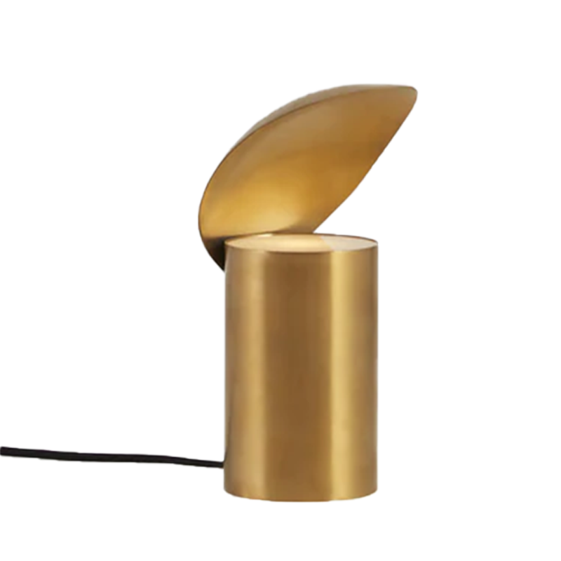 A gold colored table lamp with a shell-like design, where the lampshade is attached to the top of the cylindrical base.