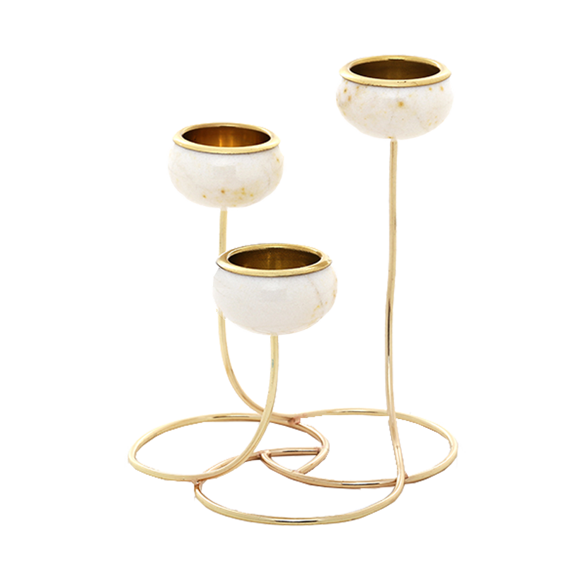 A three-tier gold and white marble candle holder with a polished gold metal base and rims, set against a solid white background.